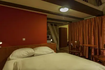 a bedroom with a bed and a red wall at A-Train Hotel in Amsterdam