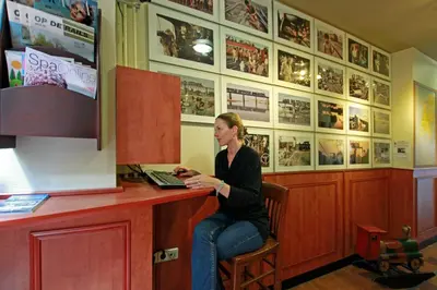 a woman sitting at a desk in a room at A-Train Hotel in Amsterdam