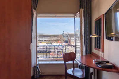 a room with a desk and a window with a view at A-Train Hotel in Amsterdam