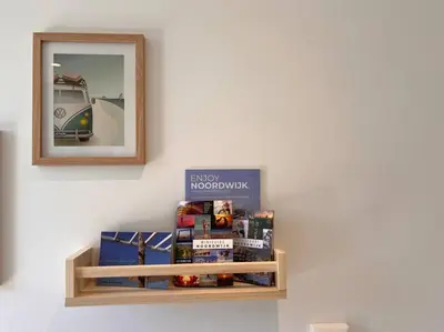 a shelf with boxes on a wall with a mirror at Have a nice stay! - Little Loft, Summerhouse near the beach in Noordwijk aan Zee
