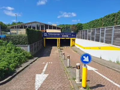 a tunnel with a sign in front of a building at Have a nice stay! - Little Loft, Summerhouse near the beach in Noordwijk aan Zee