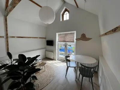 a dining room with a table and a potted plant at Have a nice stay! - Little Loft, Summerhouse near the beach in Noordwijk aan Zee
