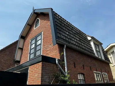 a red brick house with a black roof at Have a nice stay! - Little Loft, Summerhouse near the beach in Noordwijk aan Zee