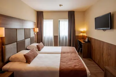 a hotel room with a bed and a flat screen tv at OZO Hotels Cordial Amsterdam in Amsterdam