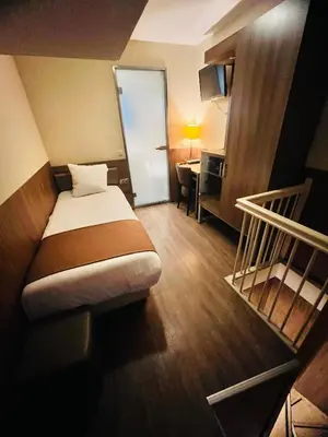 a hotel room with a bed and a desk and a staircase at OZO Hotels Cordial Amsterdam in Amsterdam
