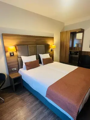 a large bed in a hotel room with two lamps at OZO Hotels Cordial Amsterdam in Amsterdam