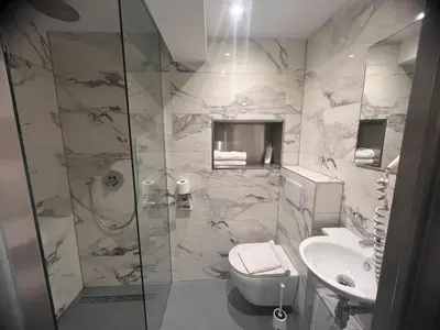 a bathroom with a shower and a toilet and a sink at OZO Hotels Cordial Amsterdam in Amsterdam