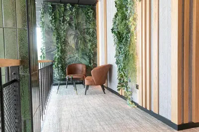 a balcony with two chairs and a table with plants at Distrikt Hotels Amsterdam Zaandam in Zaandam