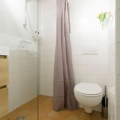 a bathroom with a toilet and a glass shower at Ground floor Jordaan Apartment in Amsterdam