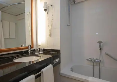 a bathroom with a sink and a tub and a mirror at Fletcher Hotel-Restaurant De Klepperman in Hoevelaken