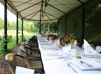 a long table in a marquee with white tables and chairs at Fletcher Hotel-Restaurant De Klepperman in Hoevelaken