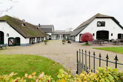 a group of white buildings with a courtyard at Fletcher Hotel-Restaurant De Klepperman in Hoevelaken