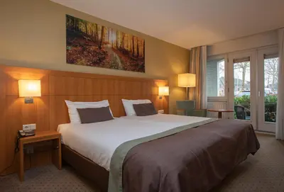 a bedroom with a large bed in a hotel room at Fletcher Hotel-Restaurant De Klepperman in Hoevelaken