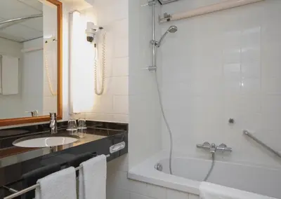 a bathroom with a tub and a sink and a shower at Fletcher Hotel-Restaurant De Klepperman in Hoevelaken