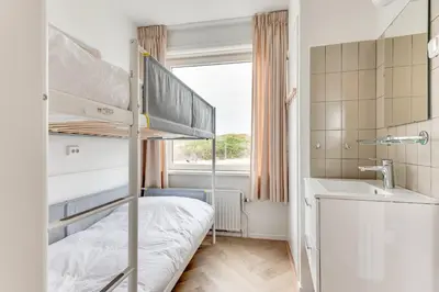 a bedroom with a bunk bed and a sink at Vernieuwd Zeezicht Villa Strand Luxe in Bergen aan Zee