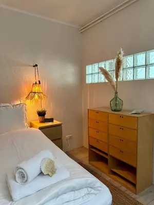a bedroom with a bed and a dresser and a window at Salt Apartment in Zandvoort