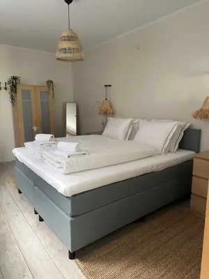 a large bed with white sheets and pillows on it at Salt Apartment in Zandvoort