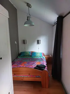 a bedroom with a bed with a colorful comforter at Natuurhuisje Eartswoud in Aartswoud