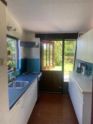 a blue kitchen with a sink and a window at Natuurhuisje Eartswoud in Aartswoud