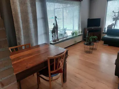 a dining room with a wooden table and a giraffe in the window at Natuurhuisje Eartswoud in Aartswoud