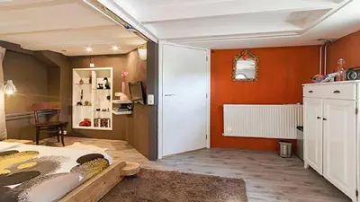 a bedroom with orange walls and a bed in a room at Benedenverdieping in Woonboot met tuinterras in Utrecht