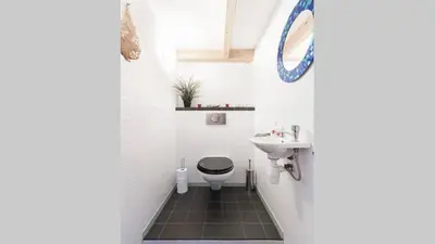 a bathroom with a toilet and a sink at Benedenverdieping in Woonboot met tuinterras in Utrecht