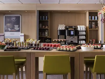 a large table with chairs and food on it at Mercure Hotel Amsterdam West in Amsterdam