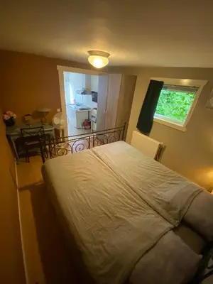a bedroom with a bed and a table and a window at La Luna - Denise in Heerhugowaard
