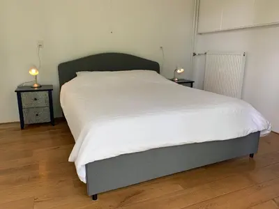 a bed in a room with two night stands and two lamps at Loveland in Bergen