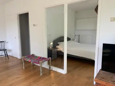 a bedroom with a bed and a mirror and a bench at Loveland in Bergen