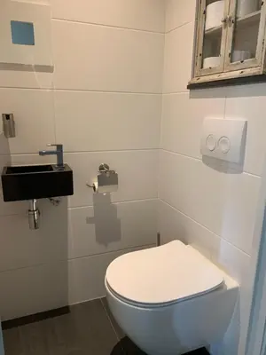 a bathroom with a white toilet and a window at Loveland in Bergen