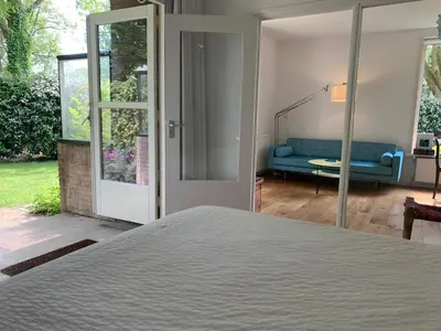 a bedroom with a bed and a blue couch at Loveland in Bergen