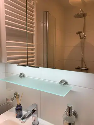 a bathroom with a glass shelf above a sink at Loveland in Bergen