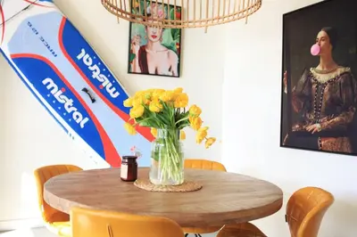 a table with a vase of yellow flowers on it at Luxury Harbour Suite With Private Parking in Loosdrecht