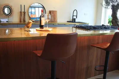 a bar with two chairs and a bottle of wine at Luxury Harbour Suite With Private Parking in Loosdrecht