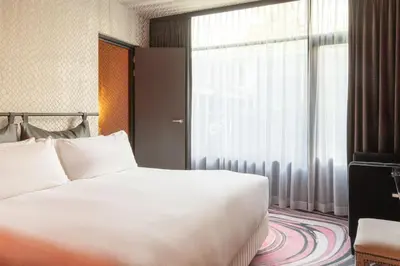 a bedroom with a bed and a large window at Apollo Hotel Amsterdam, a Tribute Portfolio Hotel in Amsterdam