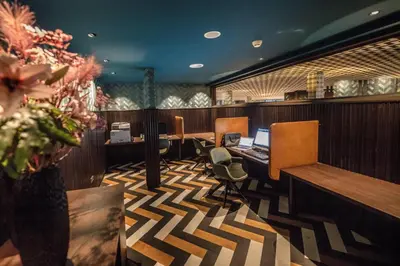 an office with a desk and chairs and a laptop at Apollo Hotel Amsterdam, a Tribute Portfolio Hotel in Amsterdam
