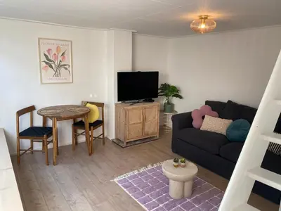 a living room with a couch and a table at Beach Bliss in Noordwijk