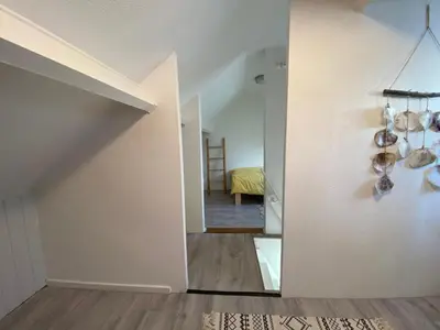 a hallway of a house with white walls and wooden floors at Beach Bliss in Noordwijk