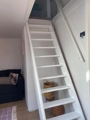 a staircase with white shelves in a room at Beach Bliss in Noordwijk