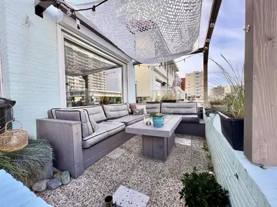 a patio with a couch and a coffee table at Odyssee in Zandvoort