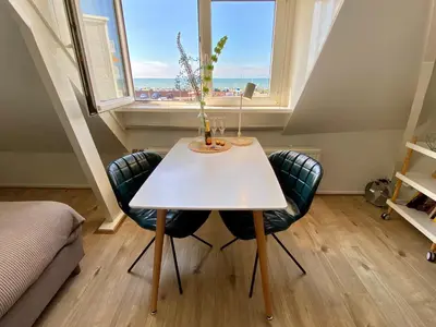 a white table and chairs in a room with a window at Odyssee in Zandvoort
