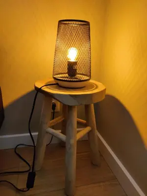 a lamp sitting on a table with a stool at Park De Driesprong in Nieuwveen