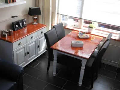 a kitchen with a wooden table with chairs and a counter at Brugman in Egmond aan Zee