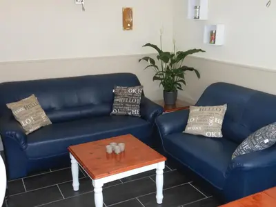 a living room with blue couches and a coffee table at Brugman in Egmond aan Zee
