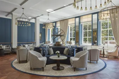 a lobby with blue walls and chairs and a table at Waldorf Astoria Amsterdam in Amsterdam