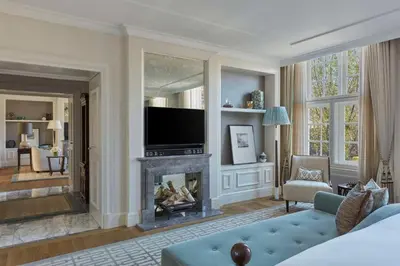 a living room with a fireplace and a television at Waldorf Astoria Amsterdam in Amsterdam