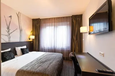 a hotel room with a bed and a television at Hotel de Duif Lisse - Keukenhof in Lisse