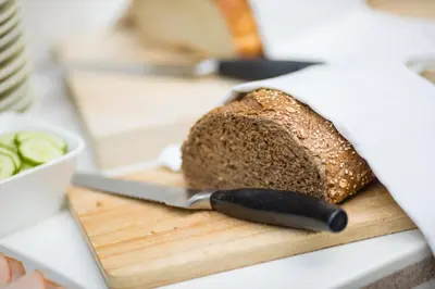a cutting board with a loaf of bread and a knife at Hotel de Duif Lisse - Keukenhof in Lisse