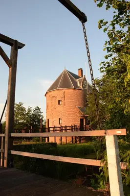 a swing in front of a large brick building at Hotel de Duif Lisse - Keukenhof in Lisse